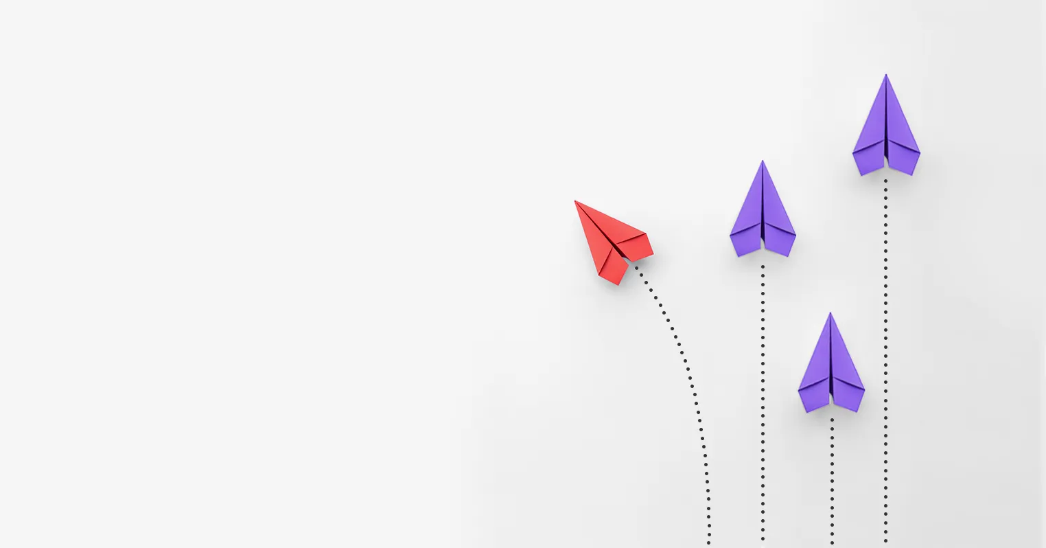 Three purple paper airplanes heading in one direction, one red paper airplane going on a different course
