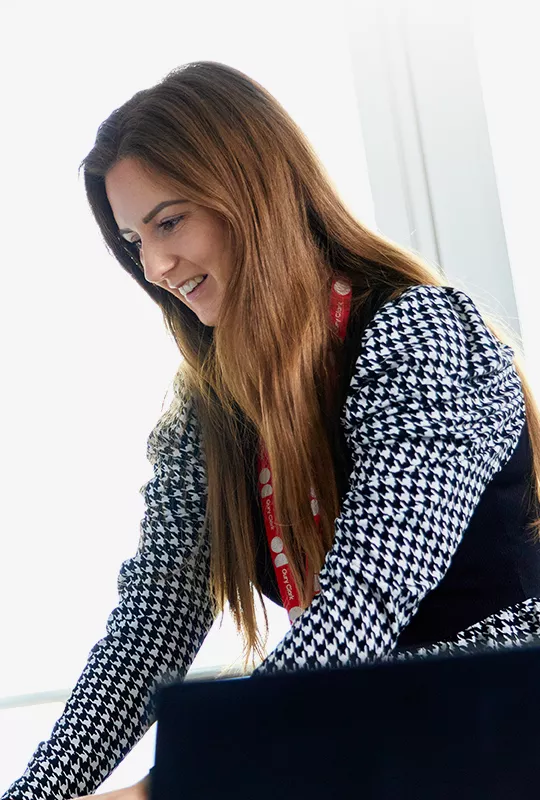 A woman wearing an Oury Clark lanyard typing on a keyboard