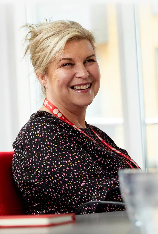 A smiling woman wearing an Oury Clark lanyard