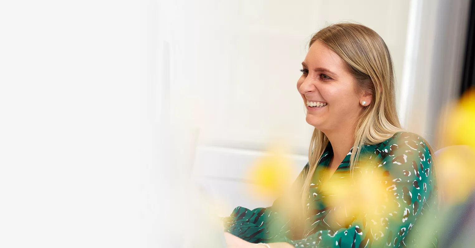 A laughing woman in a green blouse