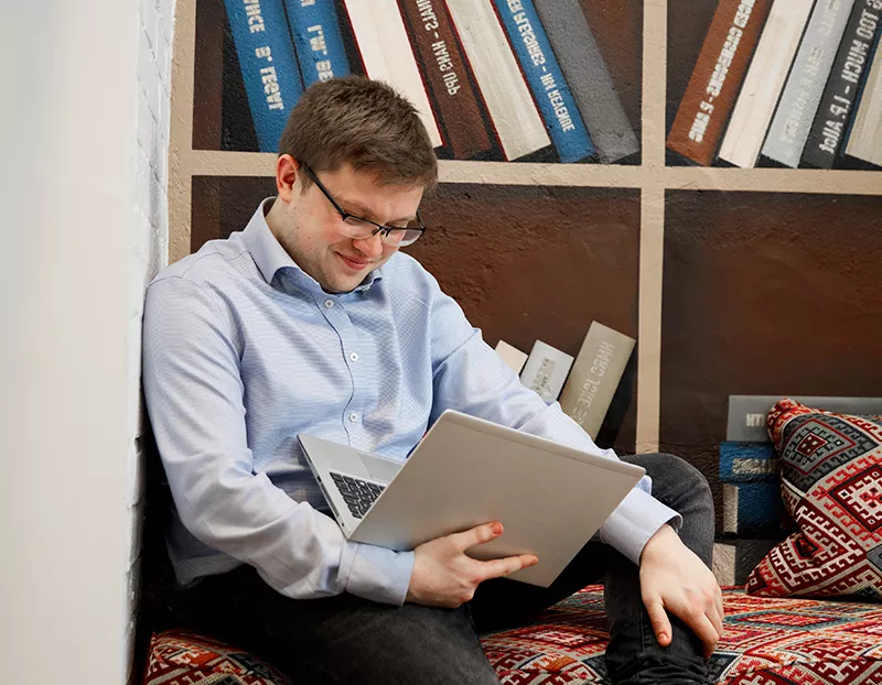 A man sat down looking at a laptop
