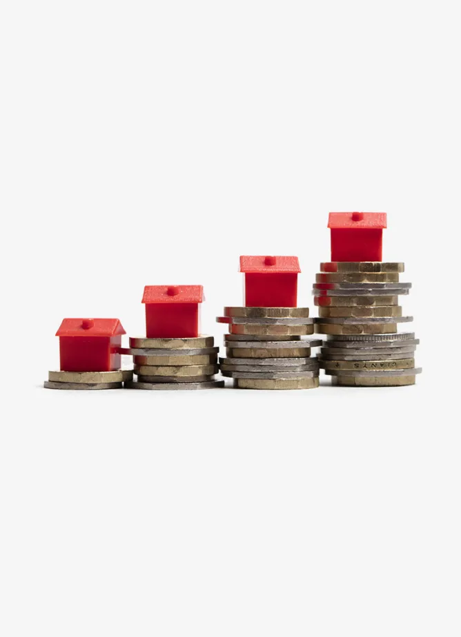 Four different-sized piles of coins, with a red monopoly house on top of each