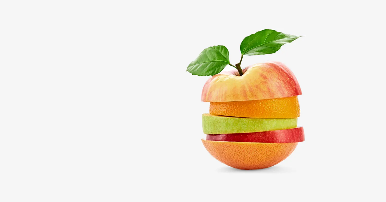 Photo showing a variety of apples and oranges sliced in section and placed together to form a lopsided fruit