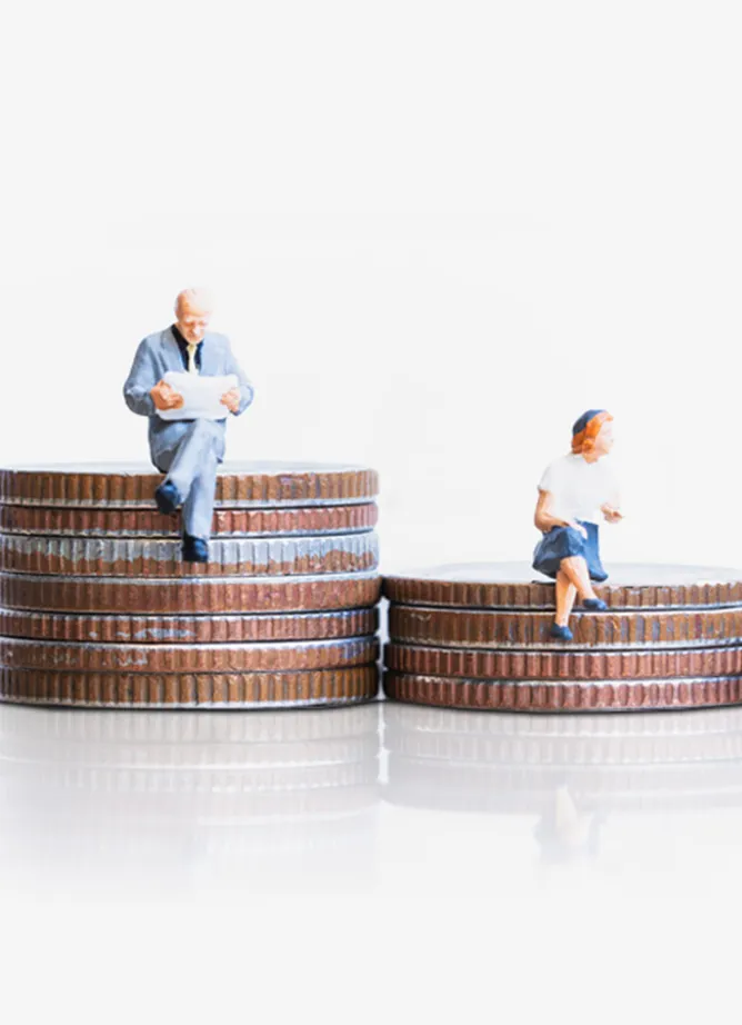 Two different sized piles of coins, with toy figures on a man sitting on the taller one, a woman sat on the smaller one