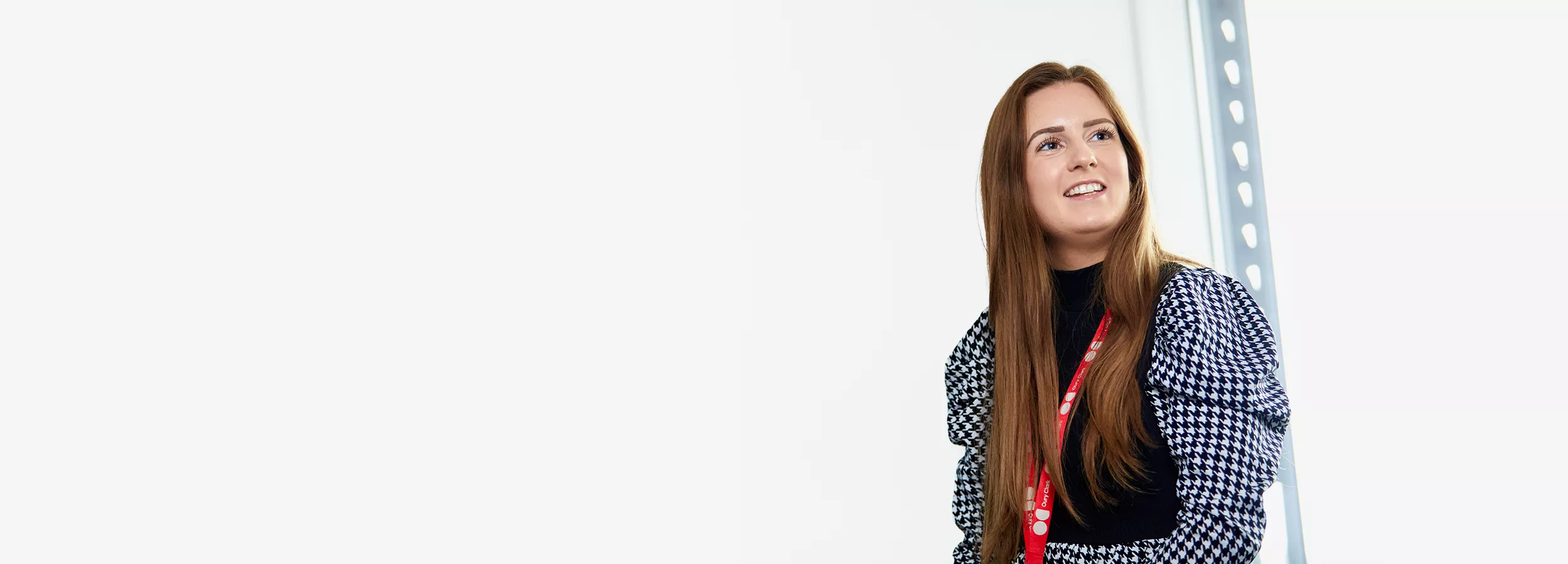 A photo of a smiling woman wearing an Oury Clark lanyard